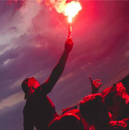 Football fan celebrating with red flare